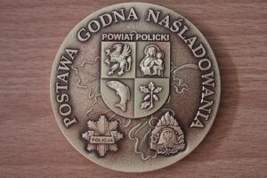 Zdjęcie przedstawia rewers medalu Postawy Godnej Naśladowania