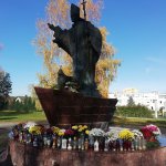 Figura św. Jana Pawła II w Policach przyozdobiona chryzantemami