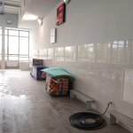 Wyposażenie sprzętu pływalni, stojące przy ścianie w metalowych koszach