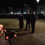 Przewodniczący Rady Powiatu w Policach Cezary Arciszewski, Członek Zarządu Powiatu w Policach Beata Chmielewska oraz Prezes Transnet S.A. Adam Pacholik składają kwiaty i znicze pod figurą św. Jana Pawła II