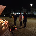 Wiceprzewodniczący Rady Powiatu w Policach Janusz Szwyd, radna Rady Powiatu w Policach Danuta Chylewska-Kęsy i radny Rady Miejskiej w Policach Damian Walczak składają kwiaty i znicze pod figurą św. Jana Pawła II