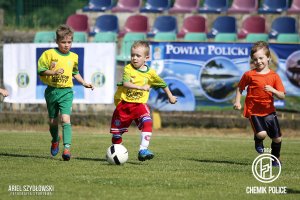 Trzech chłopców grających w piłke na murawie