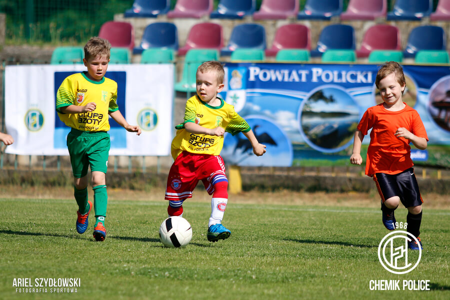 Trzech chłopców grających w piłke na murawie