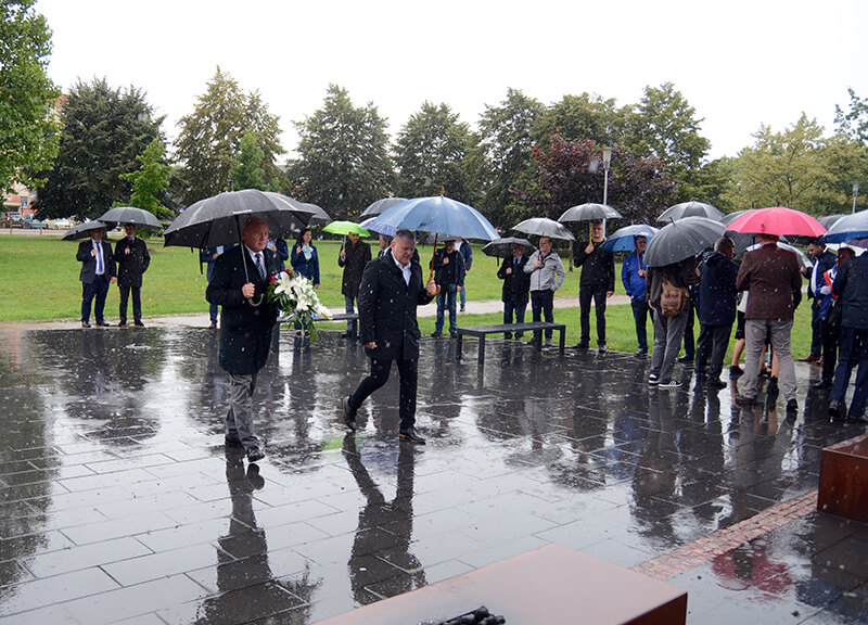 Przewodniczący Rady Powiatu w Policach Cezary Arciszewski wraz z Adamem Pacholikiem Prezesem Trans-Net składają kwiaty przed pomnikiem Ludziom Solidarności w Policach