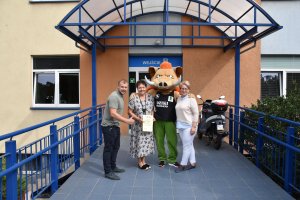 Organizator Dzikiego Weekendu Wojciech Bobrowski wraz z przedstawicielami Powiatu Polickiego: Wicestarostą Polickim Joanną Napiwodzką i Członkiem Zarządu Powiatu w Policach Beatą Chmielewską pozujący do zdjęcia z maskotką wydarzenia - "Pluszowym Dzikiem"