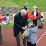 Przewodniczący Rady Powiatu w Policach Cezary Arciszewski wręcza medal uczestnikowi imprezy