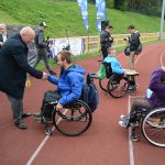 Przewodniczący Rady Powiatu w Policach Cezary Arciszewski wręcza medal uczestnikowi imprezy