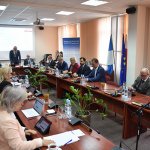 Radni Rady Powiatu w Policach siedzą przy stole w sali sesyjnej