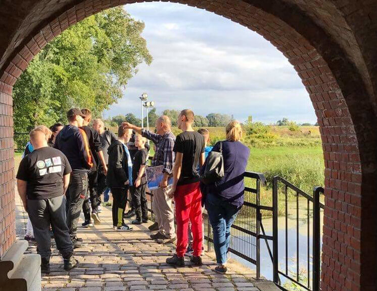 Uczestnicy projektu Dalsze podróże po świecie w trakcie zwiedzania, stoją na moście nad rzeką