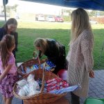 Uczennica po badaniu w Dentobusie odbiera upominku z namiotu promocyjnego