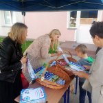 Uczeń po badaniu w Dentobusie odbiera upominku z namiotu promocyjnego