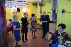 Przewodniczący Rady Powiatu w Policach Cezary Arciszewski wręcza elementy odblaskowe podczas Dnia Seniora w PZERiI w Policach
