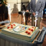 Okolicznościowy tort z okazji urodzin Stefana Marszałka, udekorowany kolorowymi kwiatami, z napisem 75 urodziny Stefana, a po środku herb Powiatu Polickiego. Na torcie trzy zapalone race