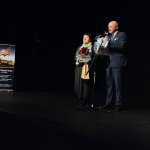 Przewodniczący Rady Powiatu w Policach Cezary Arciszewski i Członek Zarządu Powiatu w Policach Beata Chmielewska przekazują na scenie życzenia