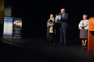 Przewodniczący Rady Powiatu w Policach Cezary Arciszewski i Członek Zarządu Powiatu w Policach Beata Chmielewska przekazują na scenie życzenia