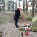 Przedstawiciel samorządu powiatowego składa kwiaty przy obelisku Longina Komołowskiego
