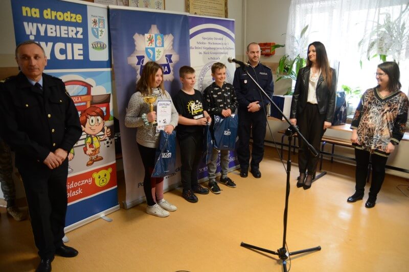 Zwycięzcy turnieju bezpieczeństwa ruchu drogowego wraz z przedstawicielami policji i powiatu polickiego na wspólnym zdjęciu