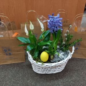 Koszyczek wielkanocny, a w tle paczki dla seniorów