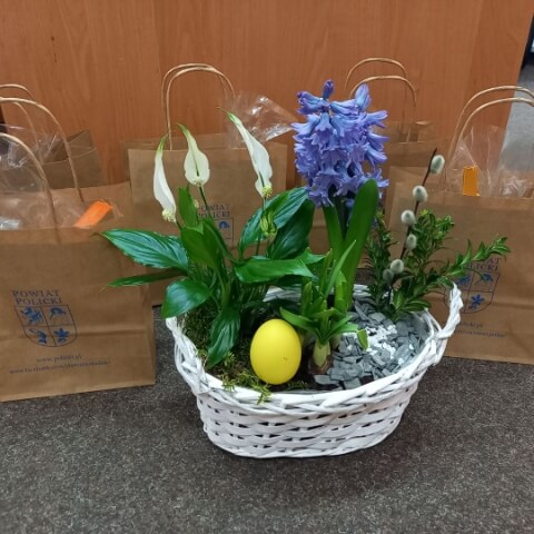 Koszyczek wielkanocny, a w tle paczki dla seniorów