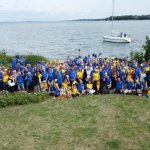 Grupowe zdjęcie gości i uczestników na tle wody, podczas oficjalnego otwarcia Etapowych Regat Turystycznych w Marinie w Trzebieży