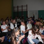 Młodzież z kolonii siedząca w salce