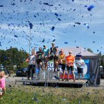 zwycięzcy biegu - seniorzy na podium, wokoł przemieszcza się konfetti