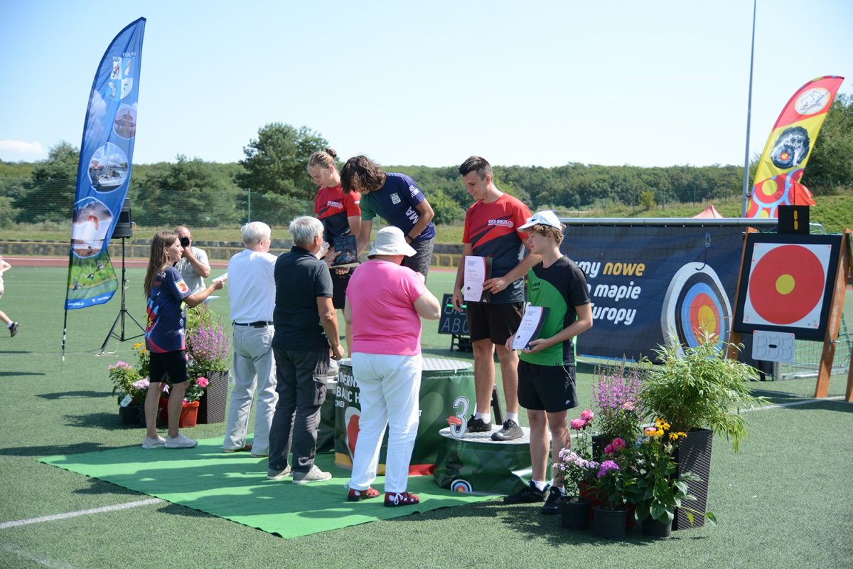 Uczestnicy turnieju łuczniczego na podium otrzymują nagrody