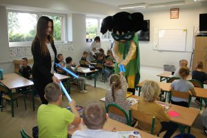 Moment rozdawania odblasków siedzącym w klasie dzieciom.