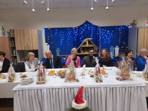 Zaproszeni goście siedzą przy wigilijnym stole