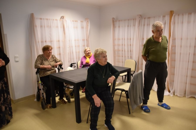 Uczetnicy Dziennego Domu Seniora plus siedzący przy stole