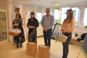 Przedstwiciele Powiatu Polickiego stojący na sali, na tle okien podczas wreczania urządzeń w ramnach Cyfrowy Senior