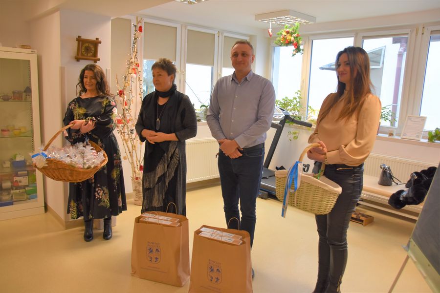 Przedstwiciele Powiatu Polickiego stojący na sali, na tle okien podczas wreczania urządzeń w ramnach Cyfrowy Senior