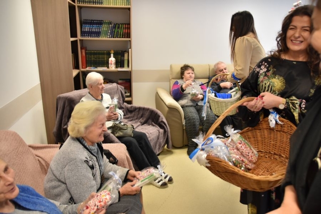 Uczestnicy Dziennego Domu Senior + siedzący na sofach