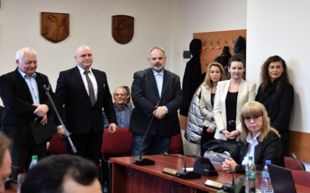 Obrady sesji Rady Powiatu w Policach, w części przeznaczonej dla widowni witani goście stoją przy krzesłach