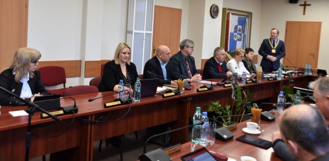 Obrady sesji Rady Powiatu w Policach, przy stołach ustawionych w literę U zasiadają Radni Powiatu Polickiego, na stojąco Starosta Policki wygłasza krótkie przemówienie do gości z Zachodniopomorskiej Izby Inżynierów Budownictwa