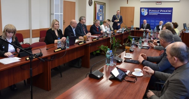 Obrady sesji Rady Powiatu w Policach, przy stołach ustawionych w literę U zasiadają Radni Powiatu Polickiego, na stojąco Starosta Policki wygłasza krótkie przemówienie do gości z Zachodniopomorskiej Izby Inżynierów Budownictwa