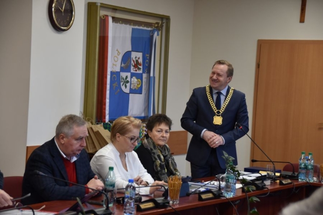 Obrady sesji Rady Powiatu w Policach, przy stole na stojąco Starosta Policki wygłasza krótkie przemówienie skierowane do przybyłych gości z Zachodniopomorskiej Izby Inżynierów Budownictwa, za stołem siedzą Wicestatrosta Policki oraz Członek Zarządu Powiatu w Policach