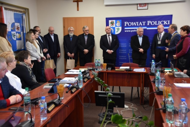 Podczas obrad sesji Rady Powiatu w Policach, goście z Zachodniopomorskiej Okręgowej Izby Inżynierów Budownictwa stoją po uroczystym wręczeniu medali