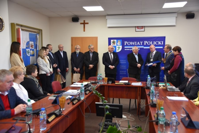 Podczas obrad sesji Rady Powiatu w Policach, goście z Zachodniopomorskiej Okręgowej Izby Inżynierów Budownictwa stoją po uroczystym wręczeniu medali