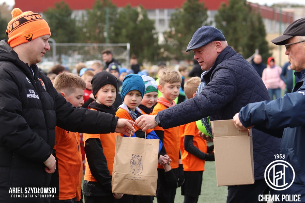 Przewodniczący Rady Powiatu Cezary Arciszewski wręcza upominek piłkarzom