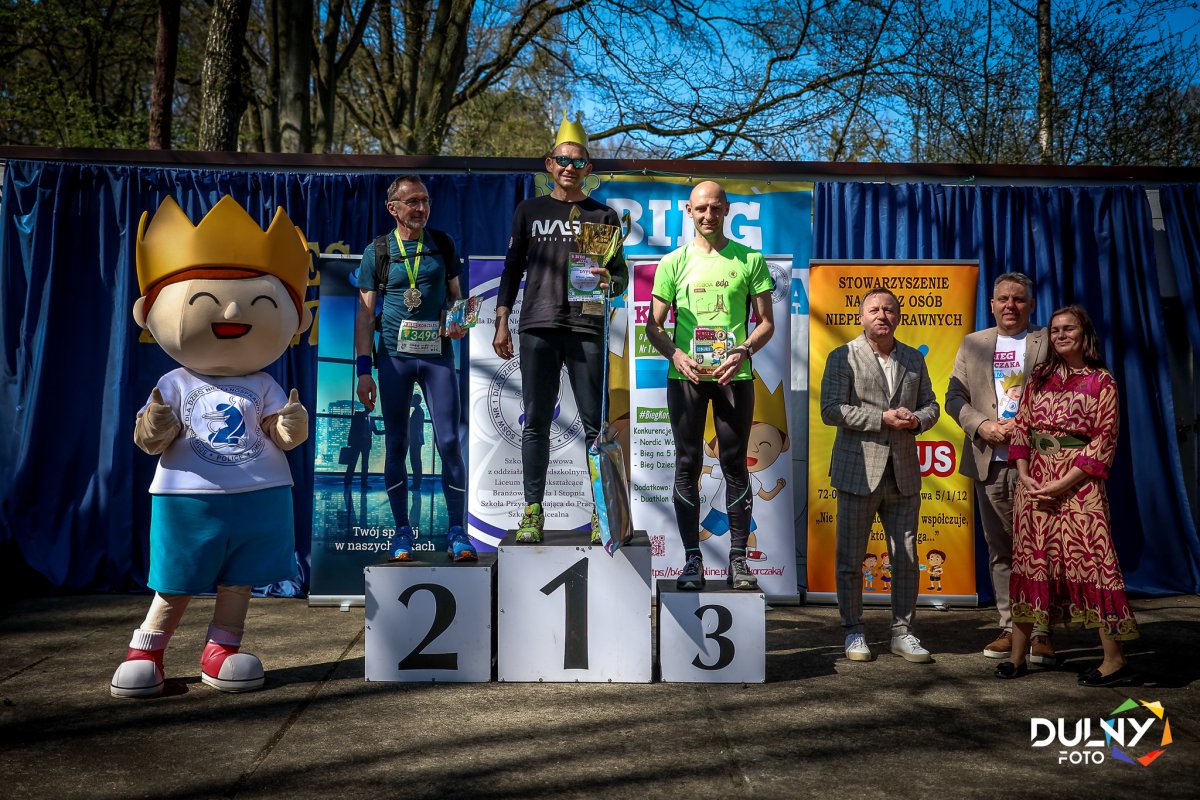 Zwycięzcy 4 Biegu Korczaka na podium wraz z wręczającymi