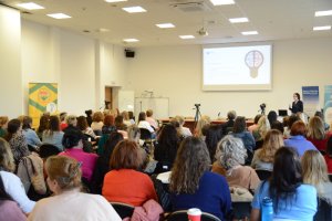 Uczestnicy konferencji dot. autyzmu siedzą tyłem. W tle prelegent stoi