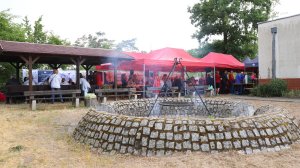 Plac na którym znajduje się palenisko, a tle namioty