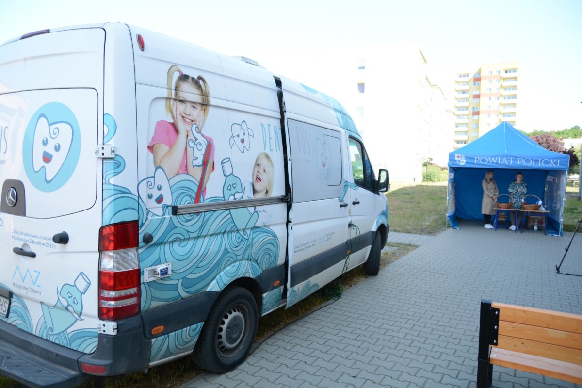 Dentobus na pierwszym planie, w tle namiot niebieski