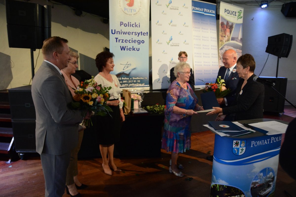 Zarząd Powiatu w Policach wręcza podziękowania Prezes PUTW, w tle banery reklamowe