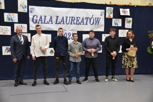 Zdjęcie pięciu nagrodzonych upominkami laureatów wraz z opiekunem.