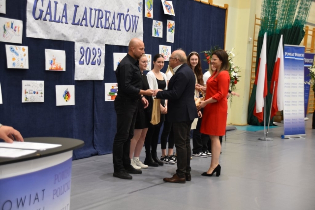 Podarowanie upominków kolejnym laureatom gali przez przedstawiciela Powiatu