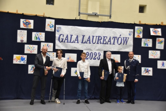 Uczniowie wraz z opiekunami pozują do grupowego zdjęcia.