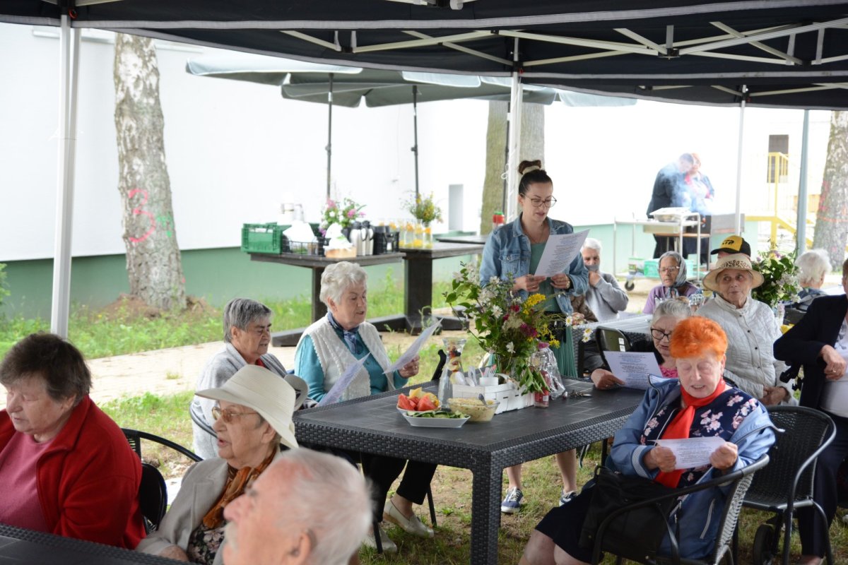 Seniorzy siedzą na ławkach