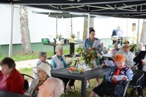 Seniorzy siedzą na ławkach